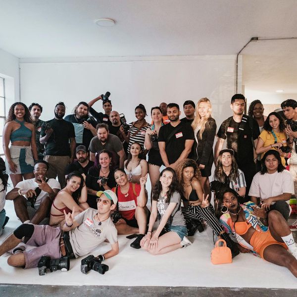 Group of diverse people smiling and sitting on yoga mats in a circle.